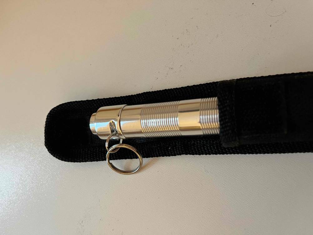 Mini-Taschenlampe getestet: Ein Gerät steckt mit der Vorderseite halb in seiner Schutzhülle.