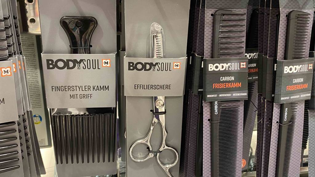 In einem Regal hängt neben anderen Produkten eine getestete Effilierschere.