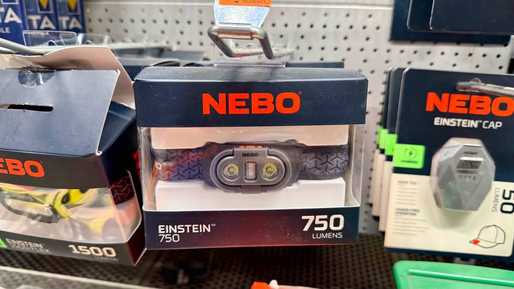 Die getestete Akku-Stirnlampe von NEBO hängt eingepackt an einem Verkaufsregal.