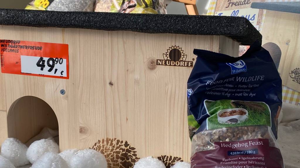 Im Test: Ein Igelhaus von vorne, an der Seite lehnt eine Packung Futter.