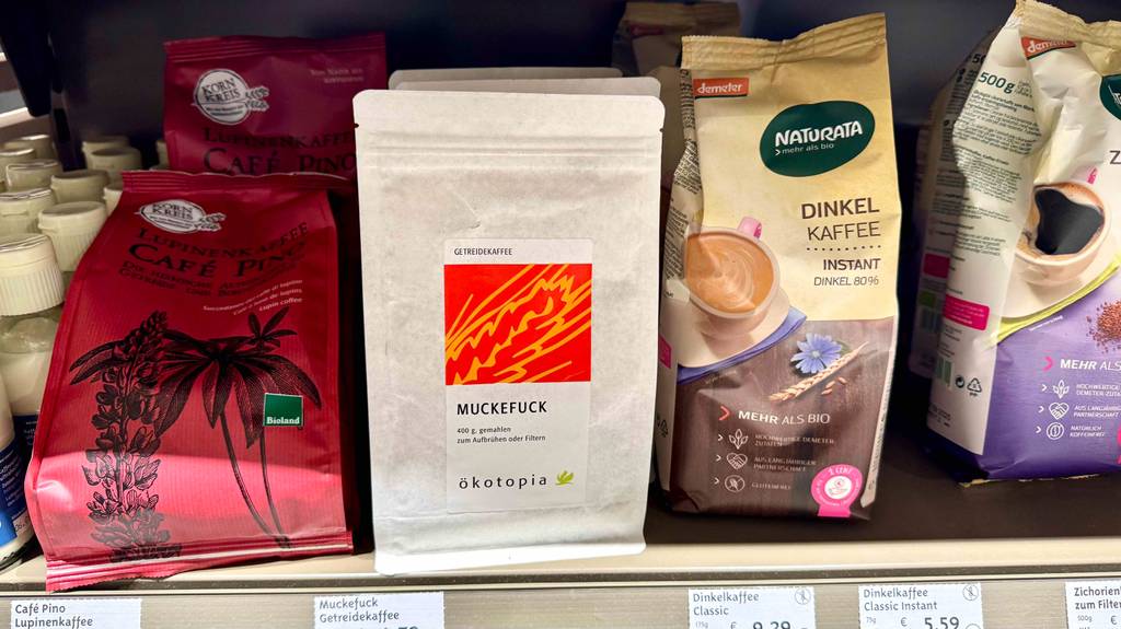 Auf einem Regal steht der getestete Getreidekaffee in der wiederverschließbaren Papiertüte neben weiteren Kaffeesorten.