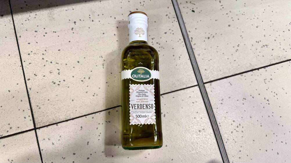 Test: Die liegende Flasche des getesteten ungefilterten Olivenöl auf einem Boden.