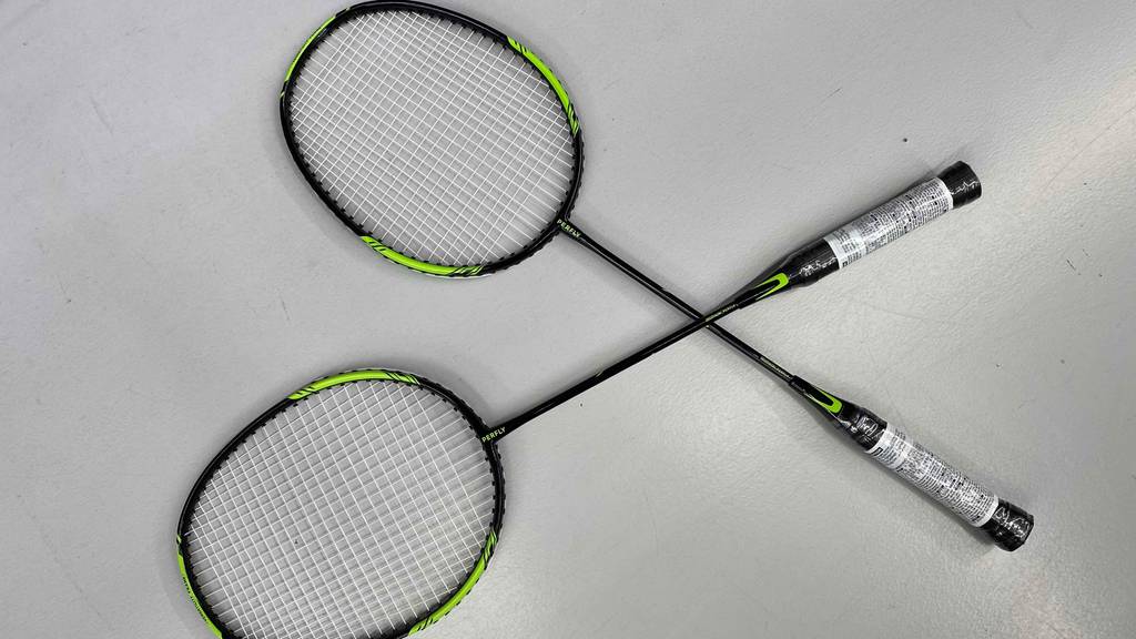Badmintonschläger im Test: Zwei Schläger liegen überkreuzt auf einer hellen Oberfläche