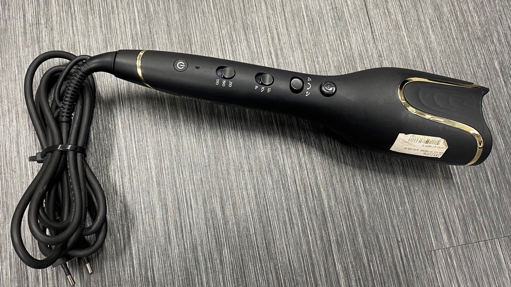 Lockenstab getestet: Detailaufnahme der Bedienelemente eines Lockenstabes auf grauem Boden