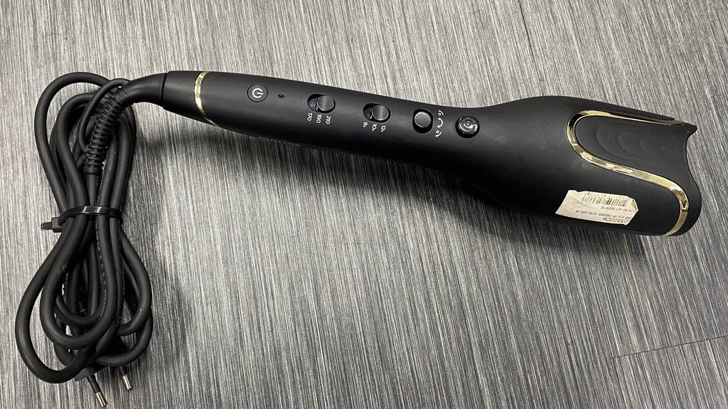 Lockenstab getestet: Detailaufnahme der Bedienelemente eines Lockenstabes auf grauem Boden