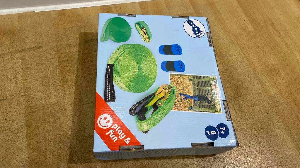 Im Test: Auf einem Holzboden liegt eine Slackline in Originalverpackung.