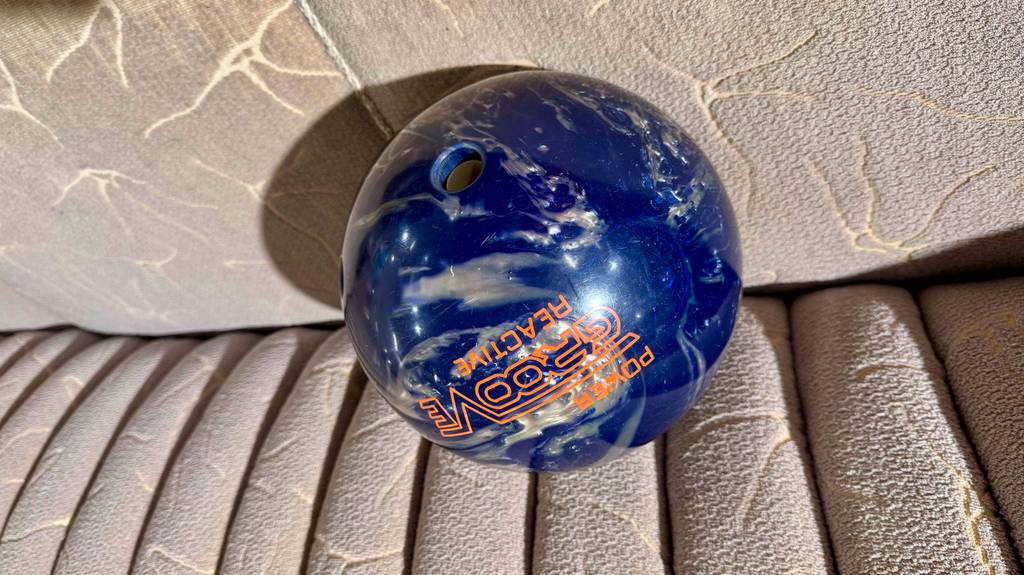 Die blaue Bowlingkugel im Test befindet sich auf einem beigefarbenen Sofa.