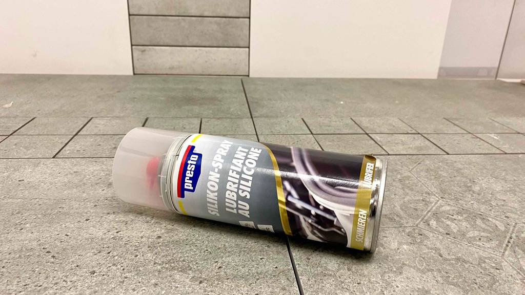 Silikonspray-Test: ein Silikonspray mit durchsichtigem Deckel auf einem Boden liegend.