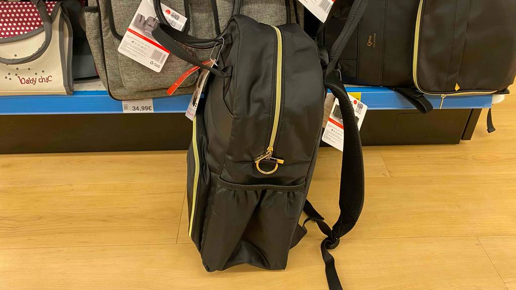 Im Test: Vor einem Regal steht auf dem Holzboden ein Wickelrucksack seitlich.
