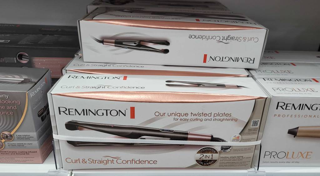 Glätteisen für Locken getestet: mehrere Verpackungen eines Remington Glätteisens, sind in einem Regal platziert.