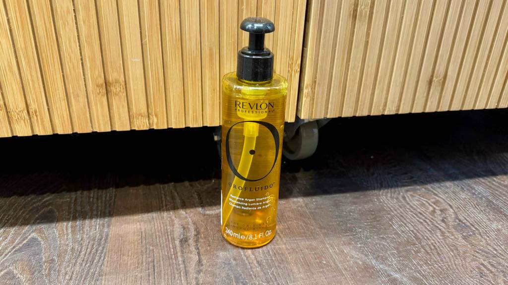 Das getestete Revlon-Shampoo das sich in einer Pumpspenderflasche befindet, ist auf einem Boden platziert.