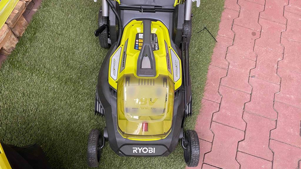 Akku-Rasenmäher getestet: gelber Akku-Rasenmäher mit 18 Volt Akku der Marke Ryobi.