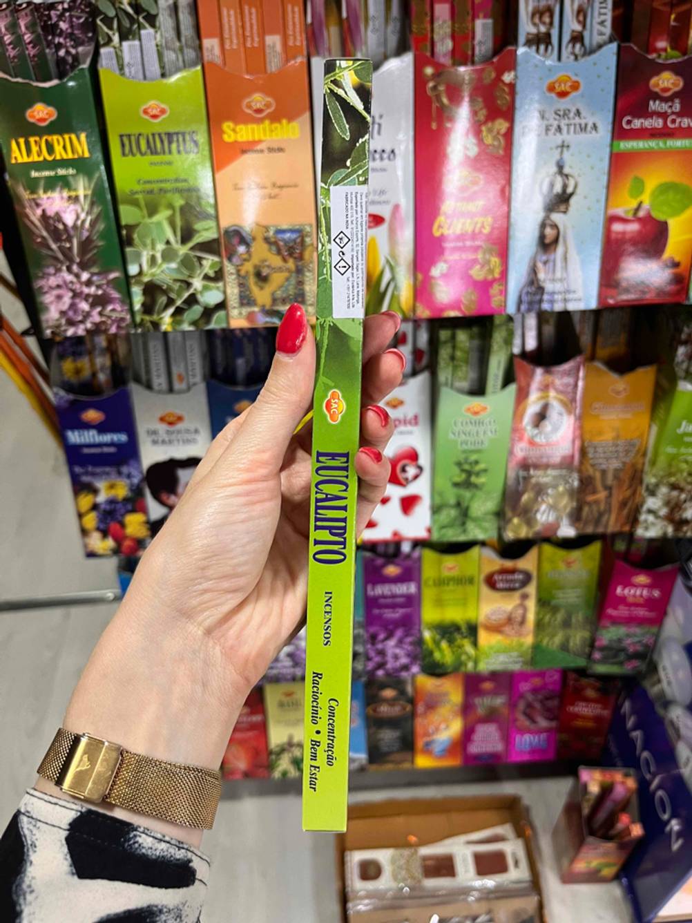 Räucherstäbchen im Test: Eine Hand hält eine Packung vor ein Regal