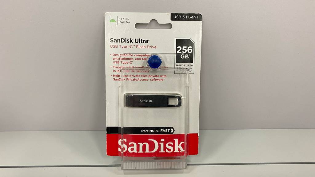 Ein getesteter USB-Stick (256 GB) in Verpackung lehnt an einer hellen Wand.