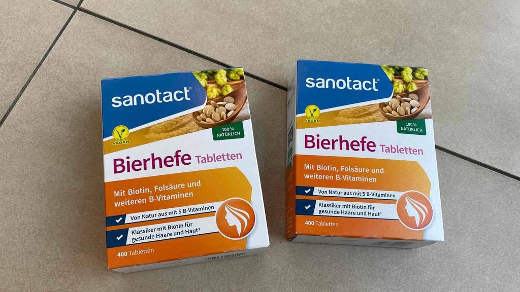 Bierhefe-Tabletten getestet: Zwei gleiche Packungen Bierhefe-Tabletten mit der Vorderseite ersichtlich auf einem Boden liegend.