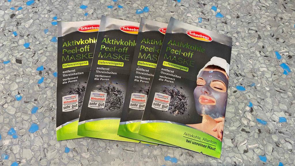 Aktivkohle-Maske getestet: Mehrere Packungen nebeneinander auf Fließenboden