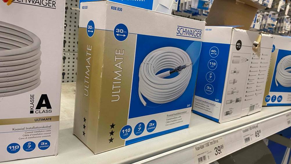 Im Test: Ein verpacktes Koaxialkabel im Regal neben anderen Packungen.