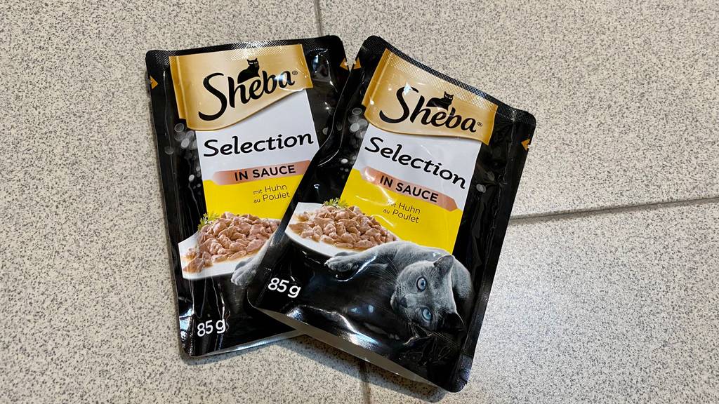 Sheba-Katzenfutter-Test: Zwei Packungen Katzenfutter auf einem Boden liegend.