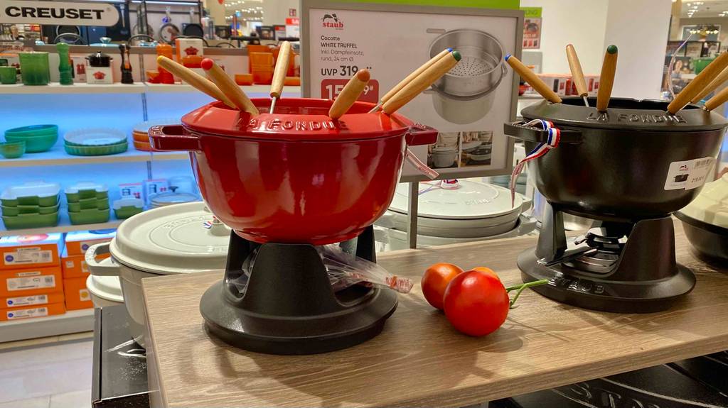 Käsefondue getestet: zwei Käsefondues in Schwarz und Rot sind in einem Geschäft ausgestellt.