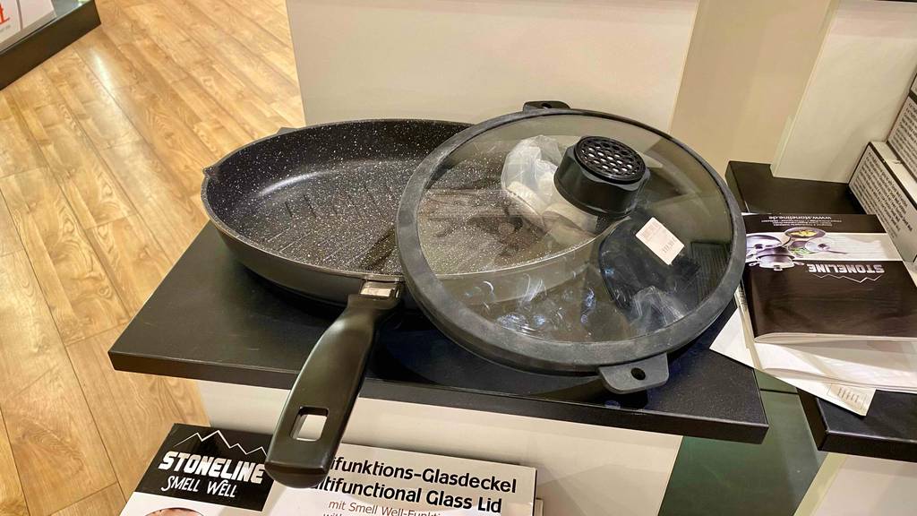 Im Test: Eine Fischpfanne mit dem Deckel daneben auf einer dunklen Fläche.
