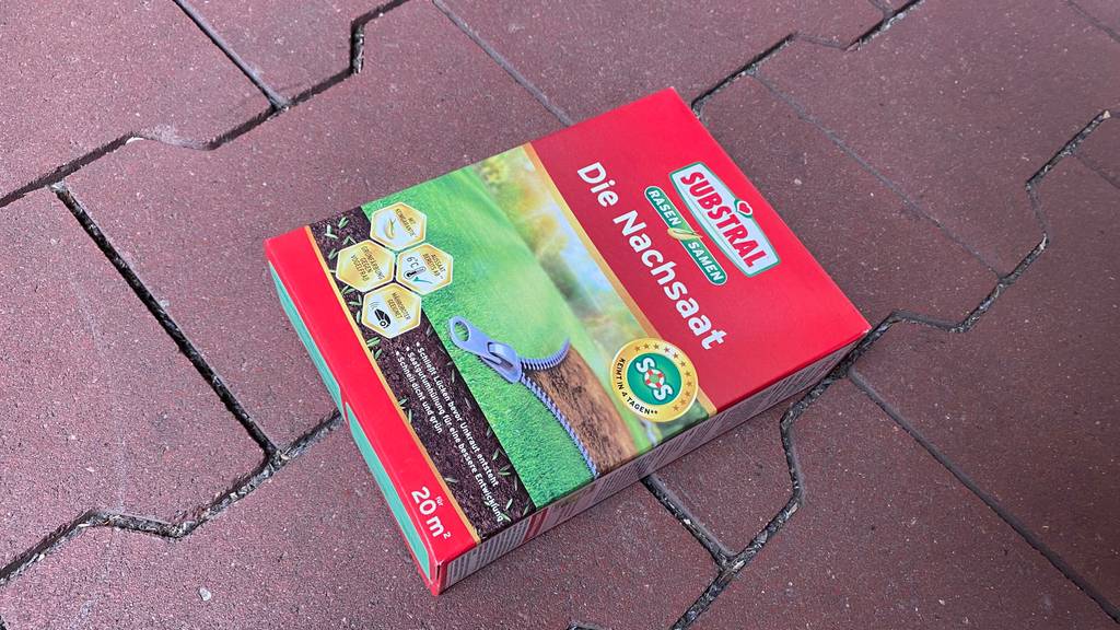 Im Test: Eine Packung Rasen-Nachsaat liegt quer auf einem Steinboden.