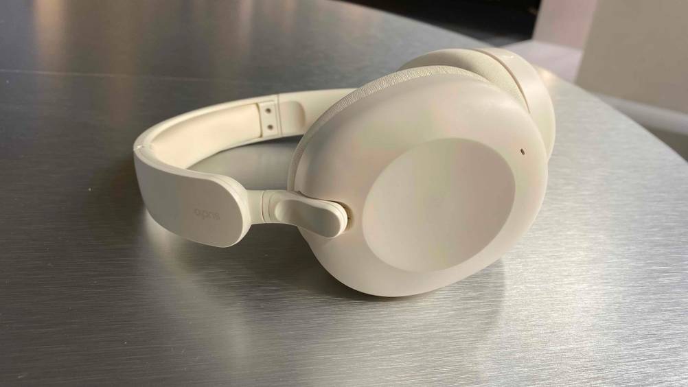 Ein getesteter Over-Ear-Kopfhörer von der Seite auf einer glänzenden Fläche.