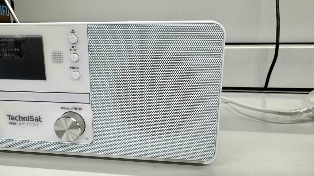 Detailansicht von vorn des Lautsprechers eines weißen Radioweckers mit CD im Test.