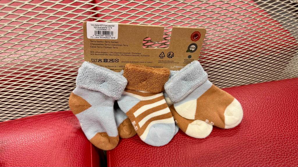 Test: Babysocken befinden sind an dem Etikett fixiert, bei welchem man die Pflegehinweise findet.