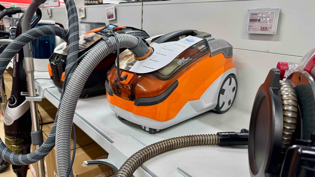 Thomas-Staubsauger im Test: Das weiß-orangefarbene Modell steht auf einem Ausstellungsregal neben weiteren Staubsaugern.