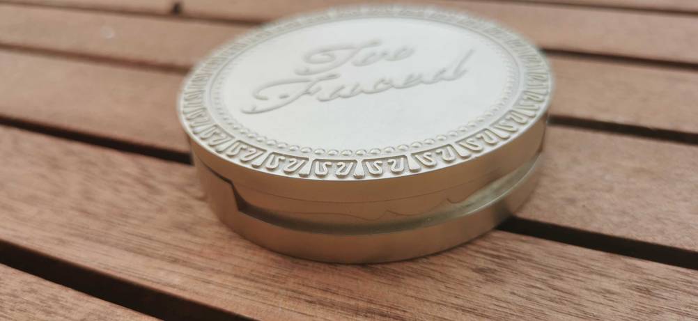Eine Dose des getesteten Bronzers von schräg vorne auf eine Holzfläche.