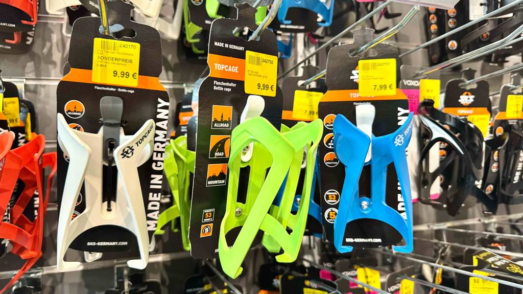 Im Test: Der Fahrrad-Flaschenhalter hängt in verschiedenen Farben an einem Verkaufsregal.