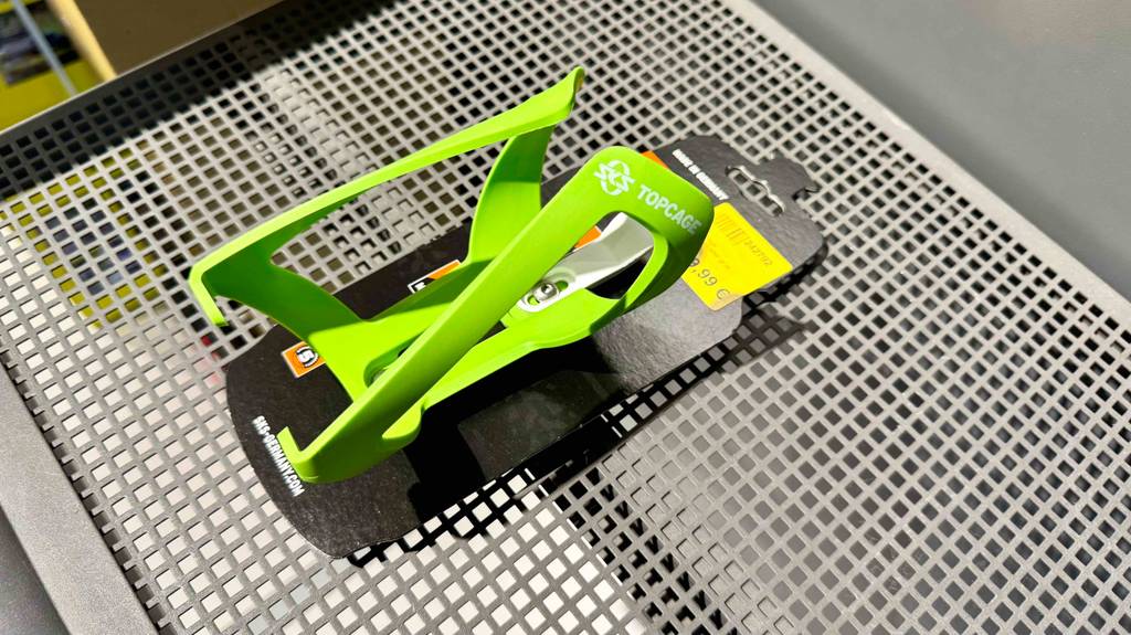 Auf einem Regal liegt der grüne Fahrrad-Flaschenhalter im Test.