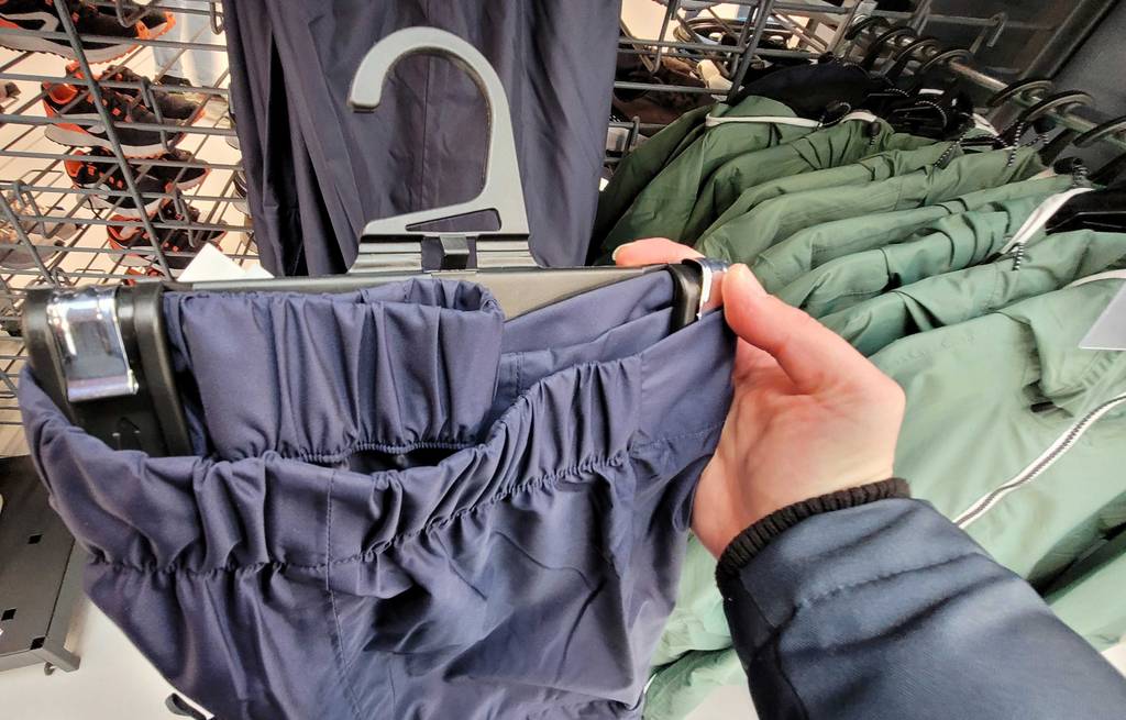 Regenhose-Herren getestet: Bund von Regenhose für Herren im Fokus auf einem Bügel befestigt.