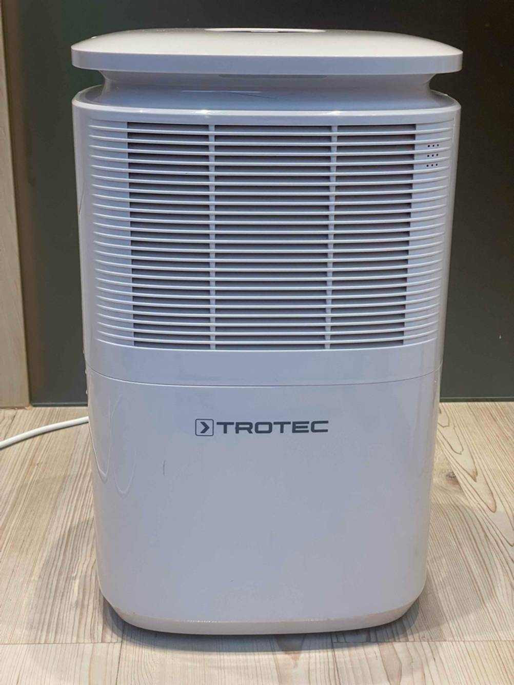 Der getestete Trotec-Luftentfeuchter von vorn auf einem Boden stehend.