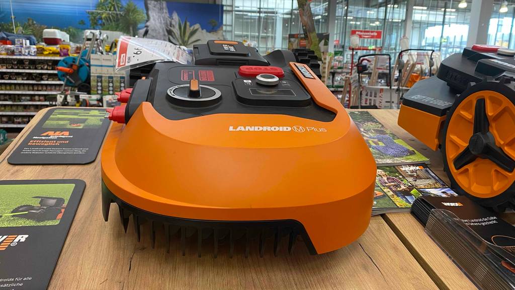 Worx-Mähroboter im Test: orangefarbener Worx-Mähroboter steht in einem Geschäft