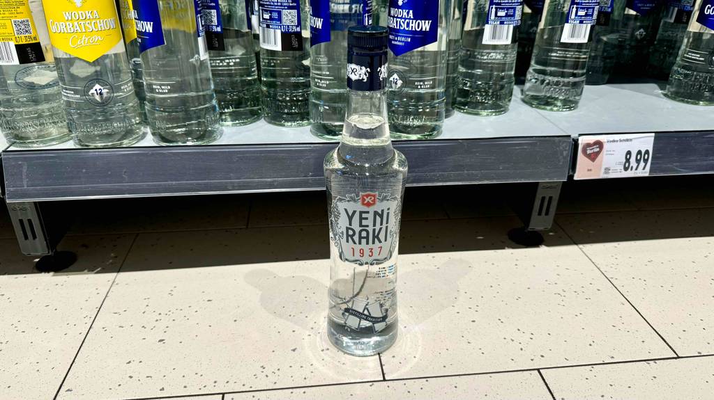 Der getestete Raki steht vor einem Regal mit anderen alkoholischen Getränken.