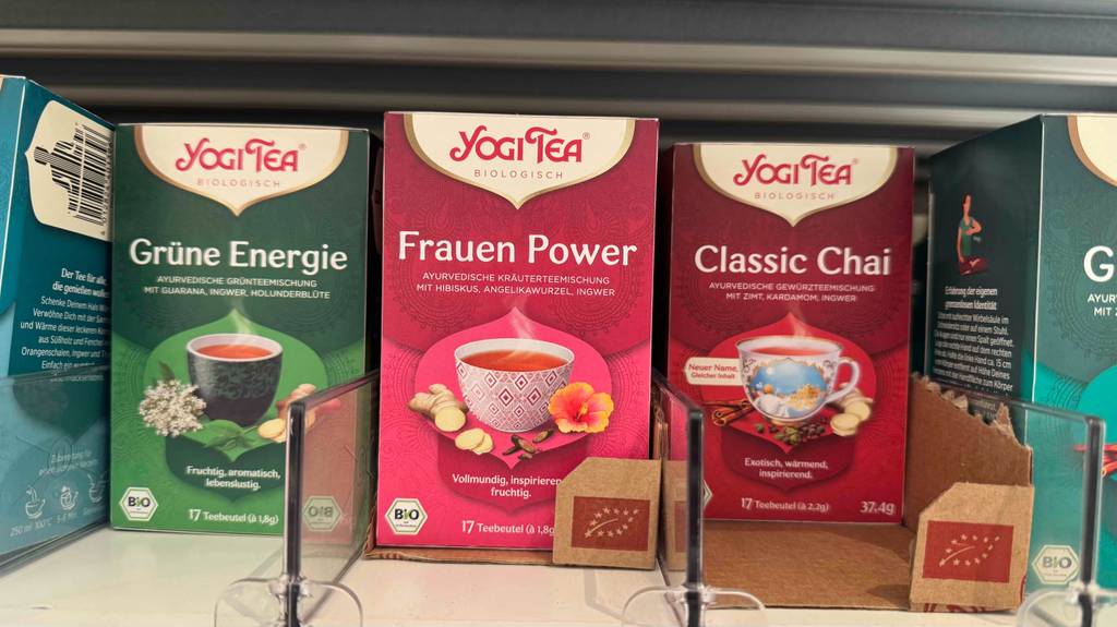 Der getestete Yogi Tea Frauen Power in der roten Verpackung steht neben weiteren Teesorten derselben Marke in einem Verkaufsregal.
