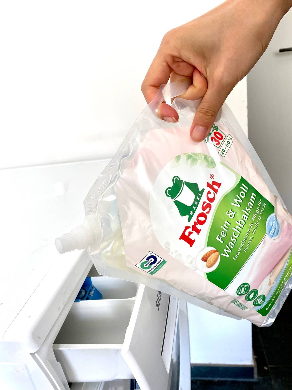 Frosch Waschmittel wird in die Waschmittelkammer gegossen.