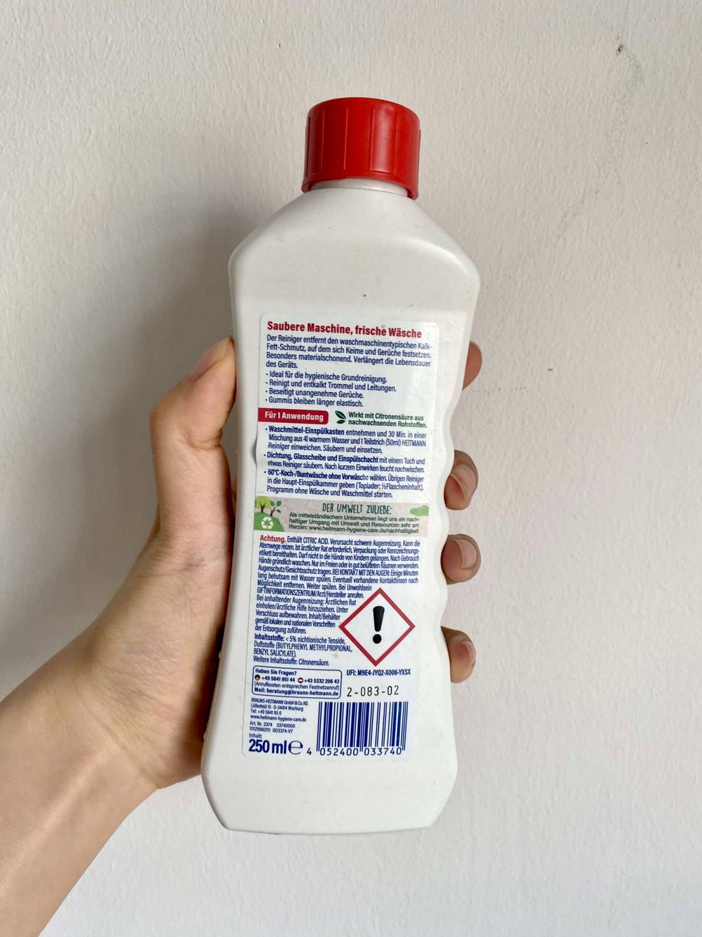Waschmaschinenreiniger mit Hand gehalten