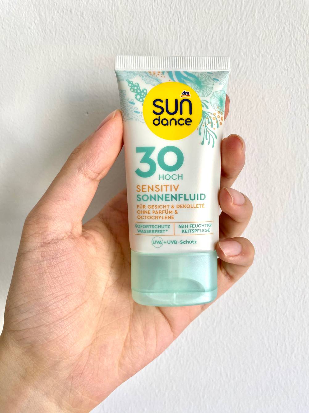 Sonenncreme in der Hand.