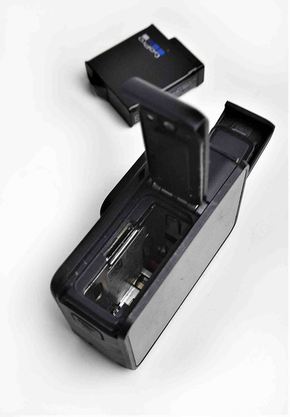 Getestet: Rückseite mit geöffnetem Batteriefach eines 4k-Camcorder im Hintergrund liegt der Akku.