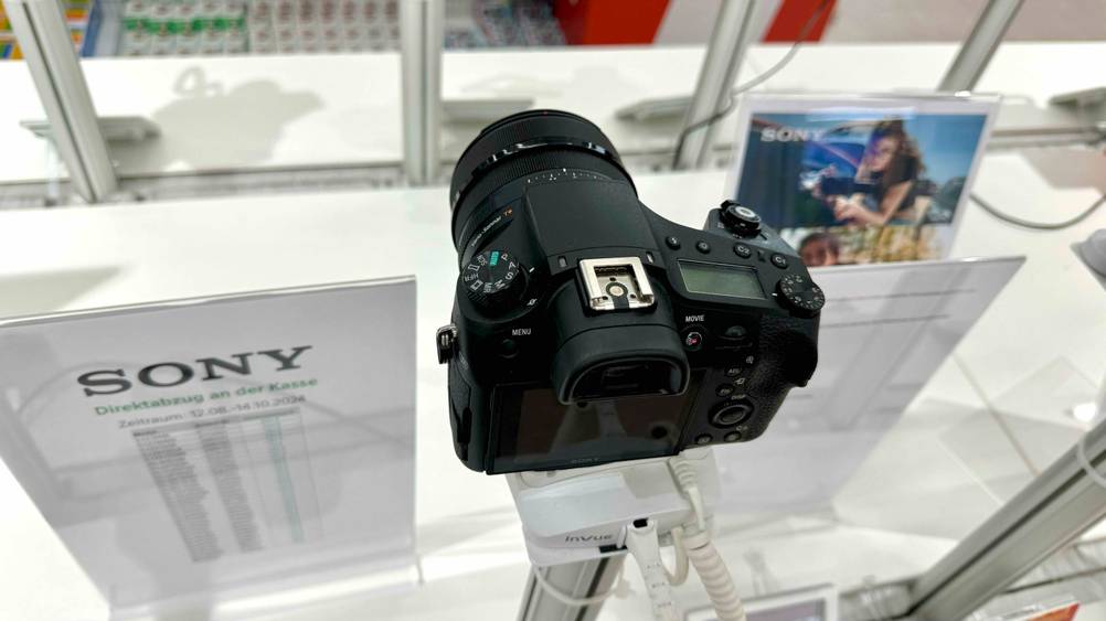 4k-Kamera getestet: Ein Gerät von oben mit Blitzschuh und Display auf einem Ständer in einer Verkaufsfläche.