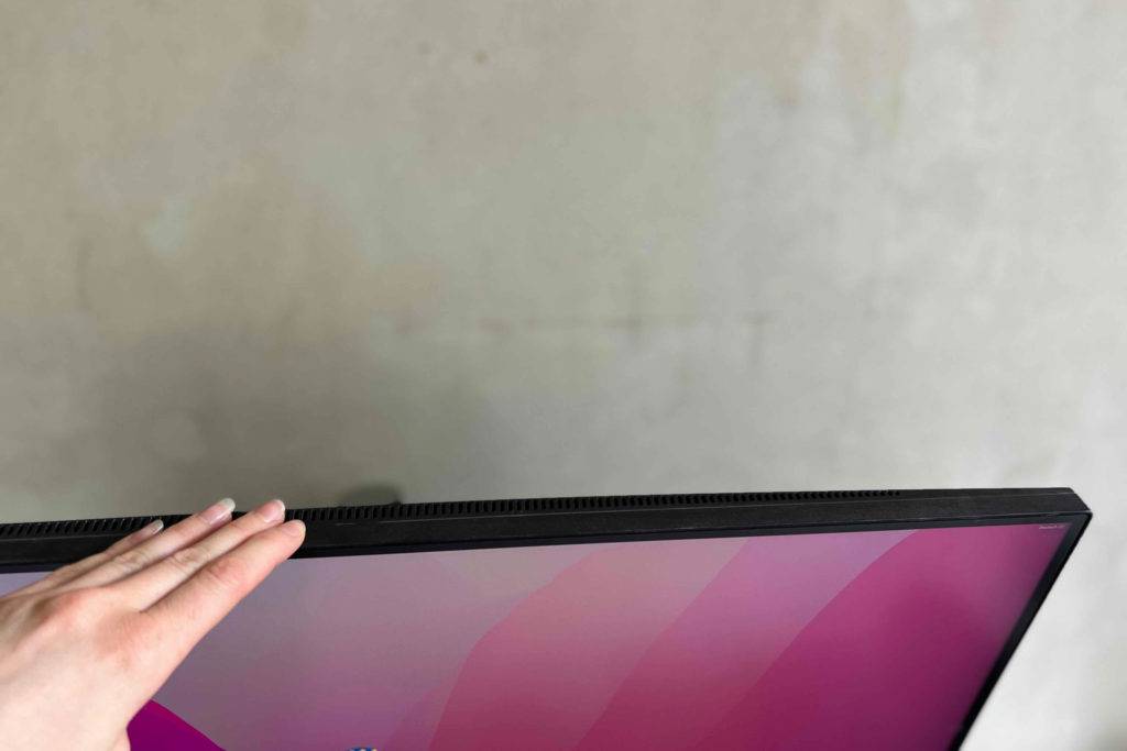 4K-Monitore im Test: Eine Frau greift an den Rahmen eines 4K-Monitors von LG.