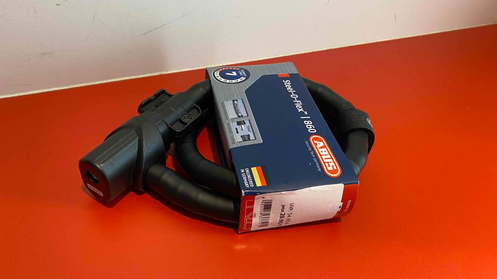 Getestetes Abus-Fahrradschloss liegt auf einer roten Ablage.