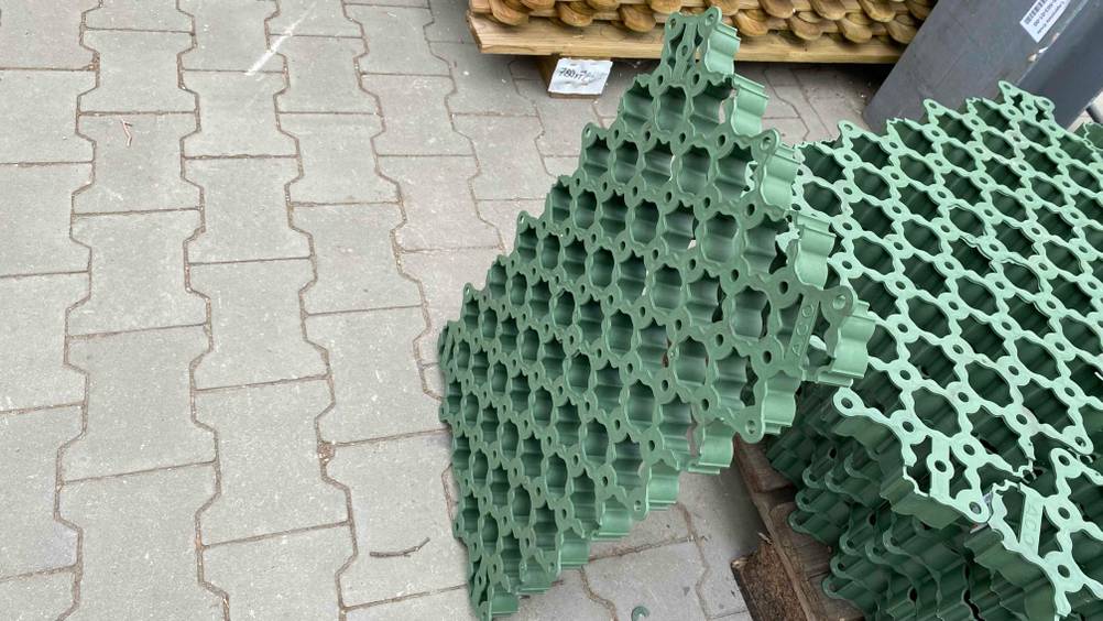 Rasengitter getestet: Ein grünes Rasengitter ist an anderen Gittern angelehnt.