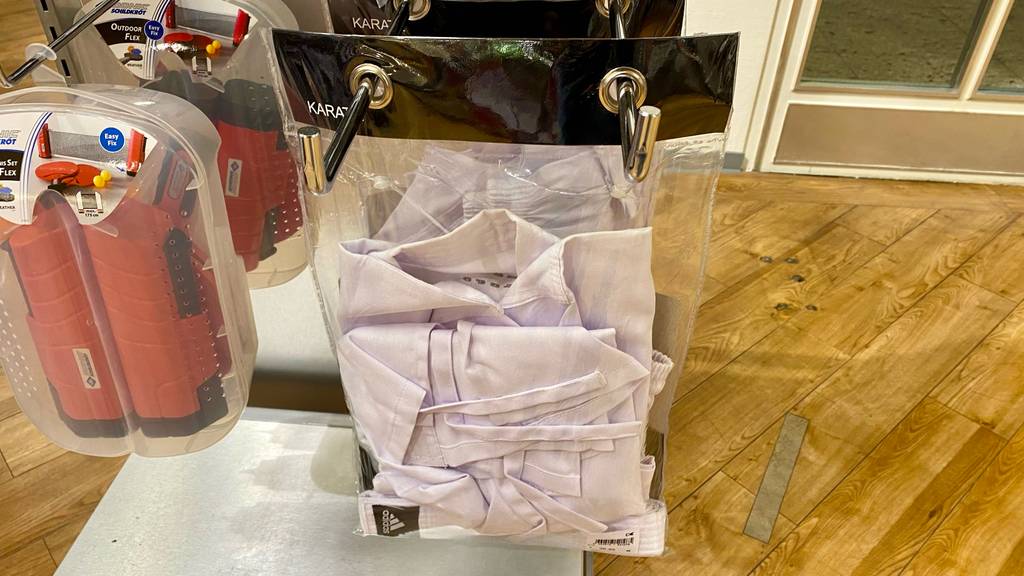 Karateanzug im Test: Karateanzug von Adidas hängt in Verpackung in einem Geschäft.