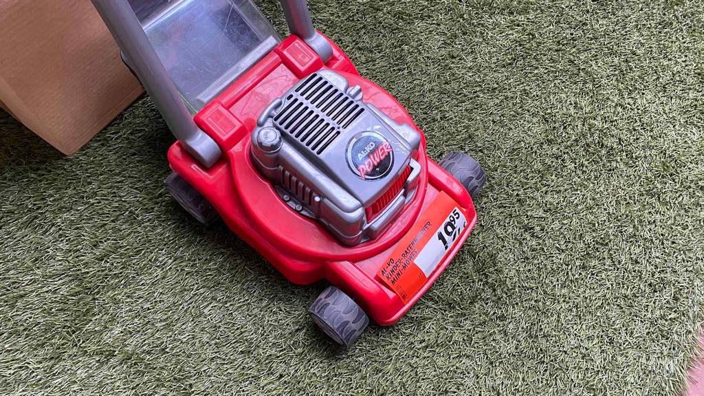 Kinder-Rasenmäher-Test: roter Kinder-Rasenmäher von vorn mit Preisschild darauf.