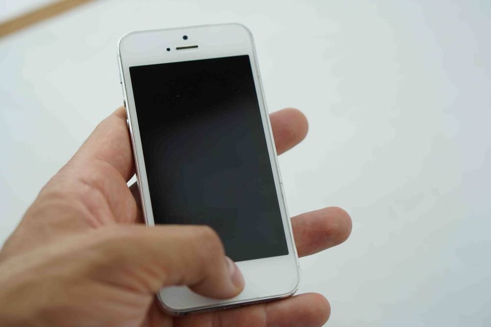 Smartphones bis 200 Euro getestet: Vor einem hellen Hintergrund liegt ein Gerät in einer Hand