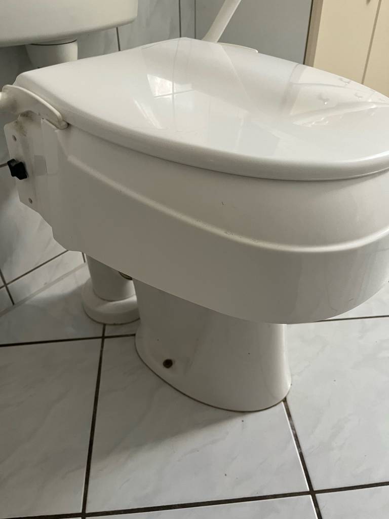 Der Rand der getesteten Toilettensitzerhöhung im Fokus.
