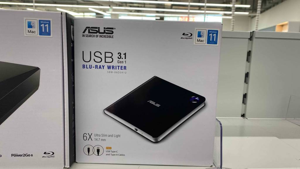 In einem Regal steht ein getesteter Blu-Ray Brenner von asus in Originalverpackung.
